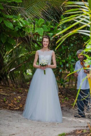 Traum Hochzeit Seychellen unter Palmen mit Braut in Hochzeitskleid und live Musik.