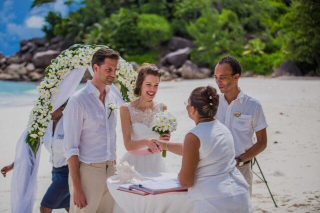 Traumhafte Seychellen Hochzeit am Strand mit weißen Blumen, unvergessliche Flitterwochen.