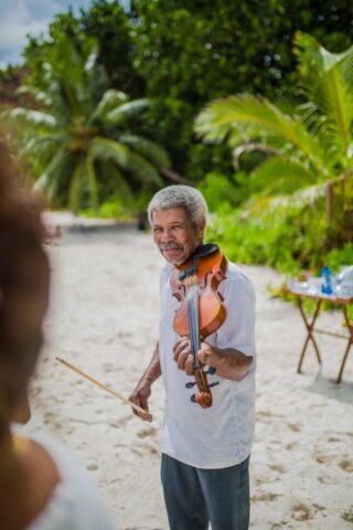 Romantische Hochzeit auf den Seychellen, Musiker mit Geige am Strand, Traumhochzeit im Paradies.