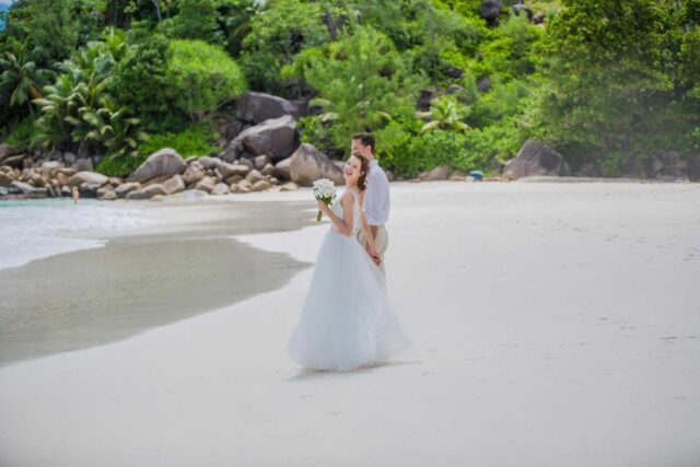 Traum Hochzeit Seychellen am Strand mit Brautpaar im romantischen Urlaubsziel.