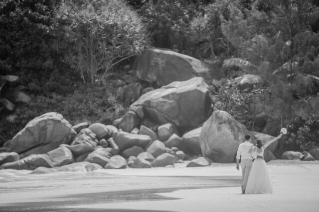 Romantische Hochzeit auf den Seychellen, Strandpaar in eleganten Braut- und Bräutegemälden.